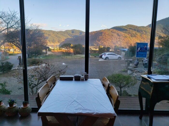 A restaurant table along a window viewing a parking lot and mountains