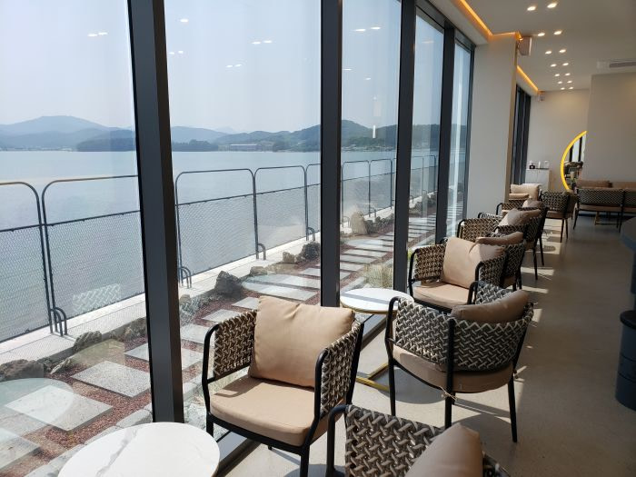 A row of cushion seats against windows and the sea