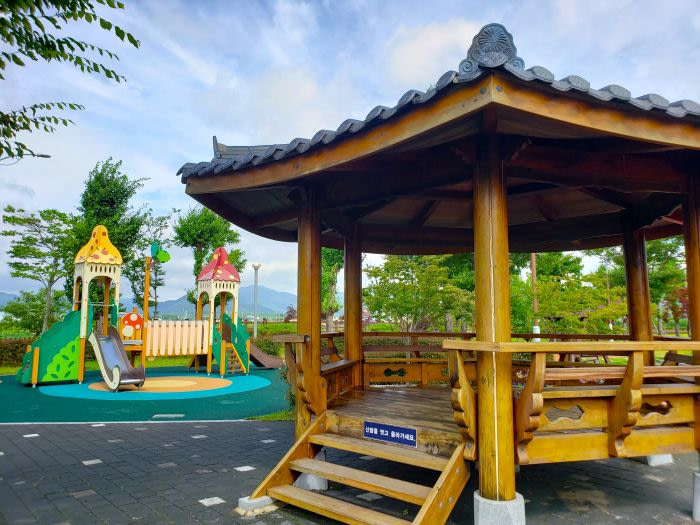 A pavilion next to a playground outside