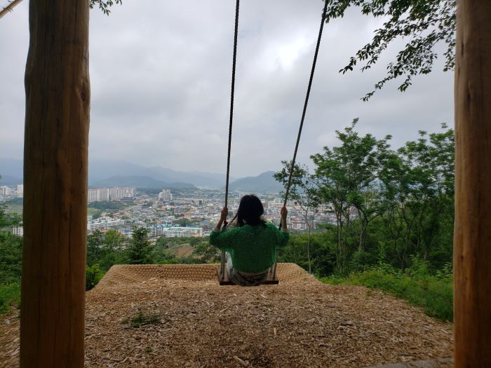 A woman swinging overlooking a town below
