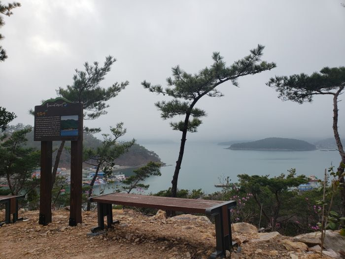 A bench facing a view of islands on a cloudy day