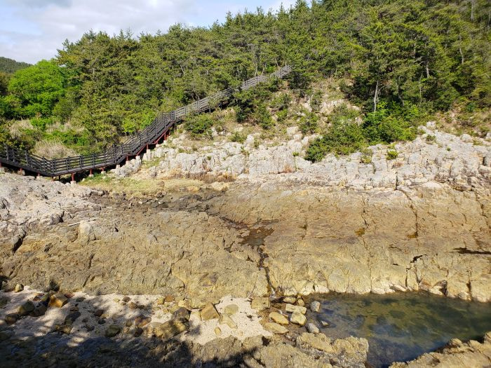 A fenced boardwalk leading across rocks and over water