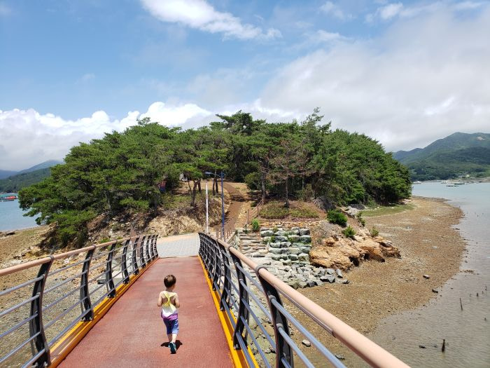 A toddler crossing a bridge entering Boli Island in Goseong, Gyeongnam, Korea