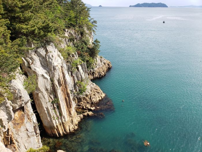 Turquoise water against columnar rock formations in Goseong, Korea