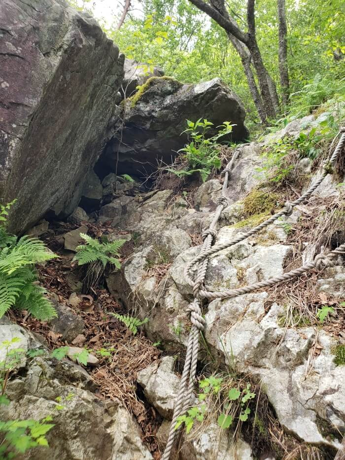 A rope dangling down the side of a large rock