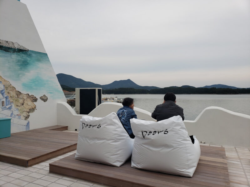 Chairs near painted mural of Greece