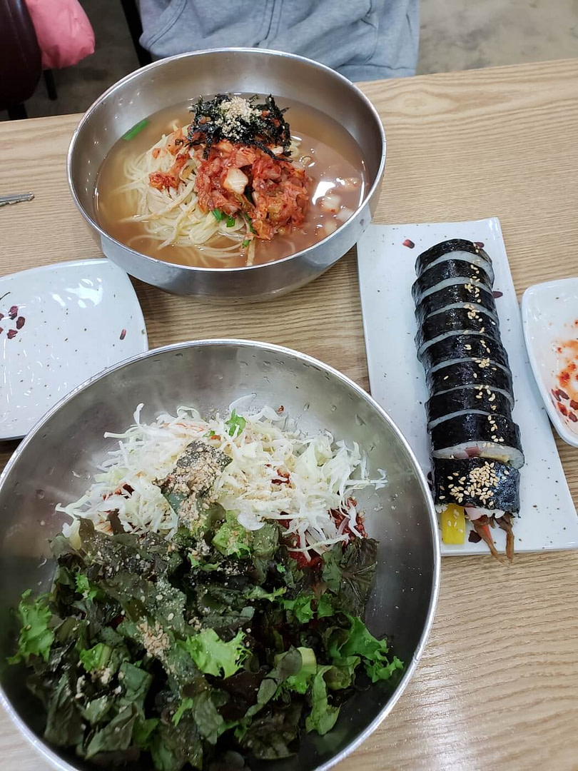 A bowl of bibim guksu and one of mul guksu before mixing