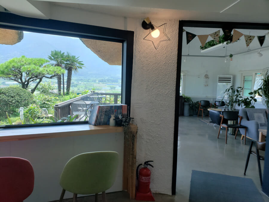 A look showing the outdoor seating and the indoor room with couches and come chairs along the windows