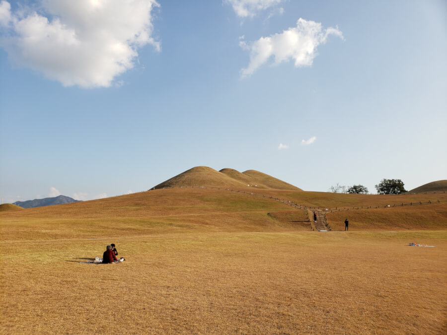 People picnicking in Songhakdong in the fall with brown grass everywhere on a sunny day