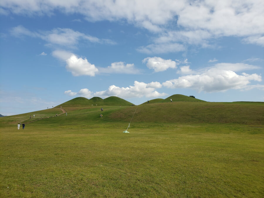 People walking along Songhakdong tombs and someone with a kite