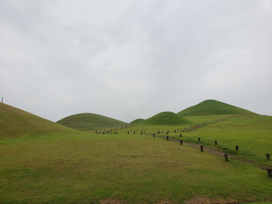 Walking trails among the green tombs on a cloudy day