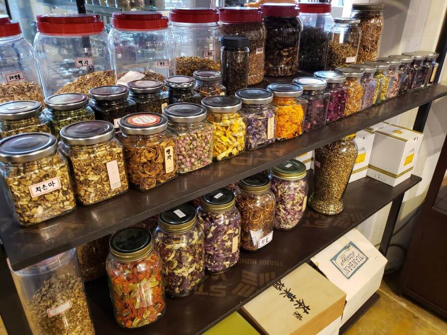 Jars of dried herbs and items for tea on shelves