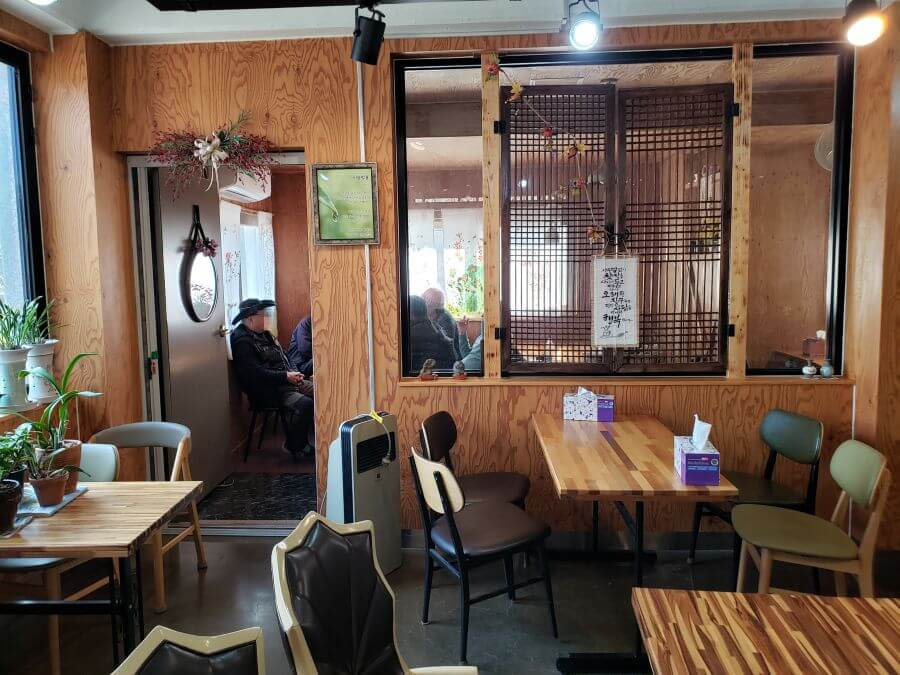 People in a café with wood tables and furniture