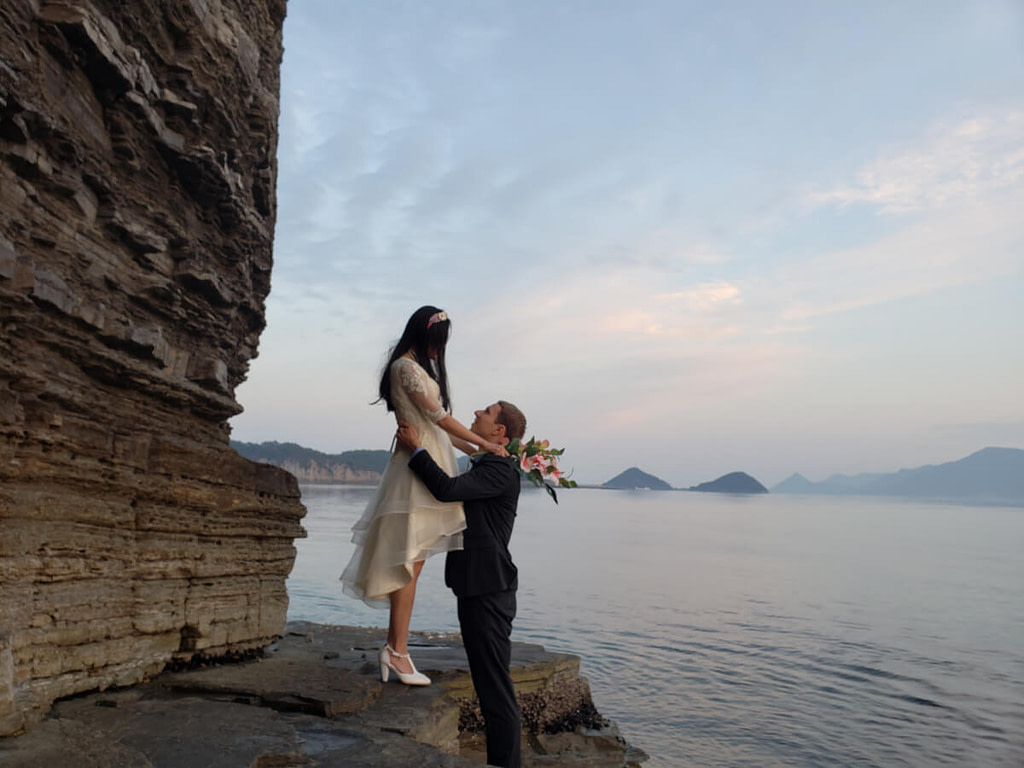 Wedding photo facing each other on the rocks