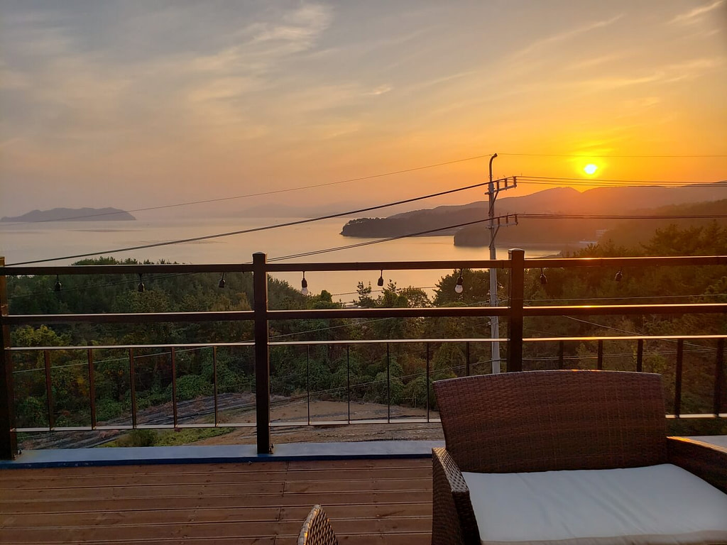 A sunset view with the sea from an outdoor deck
