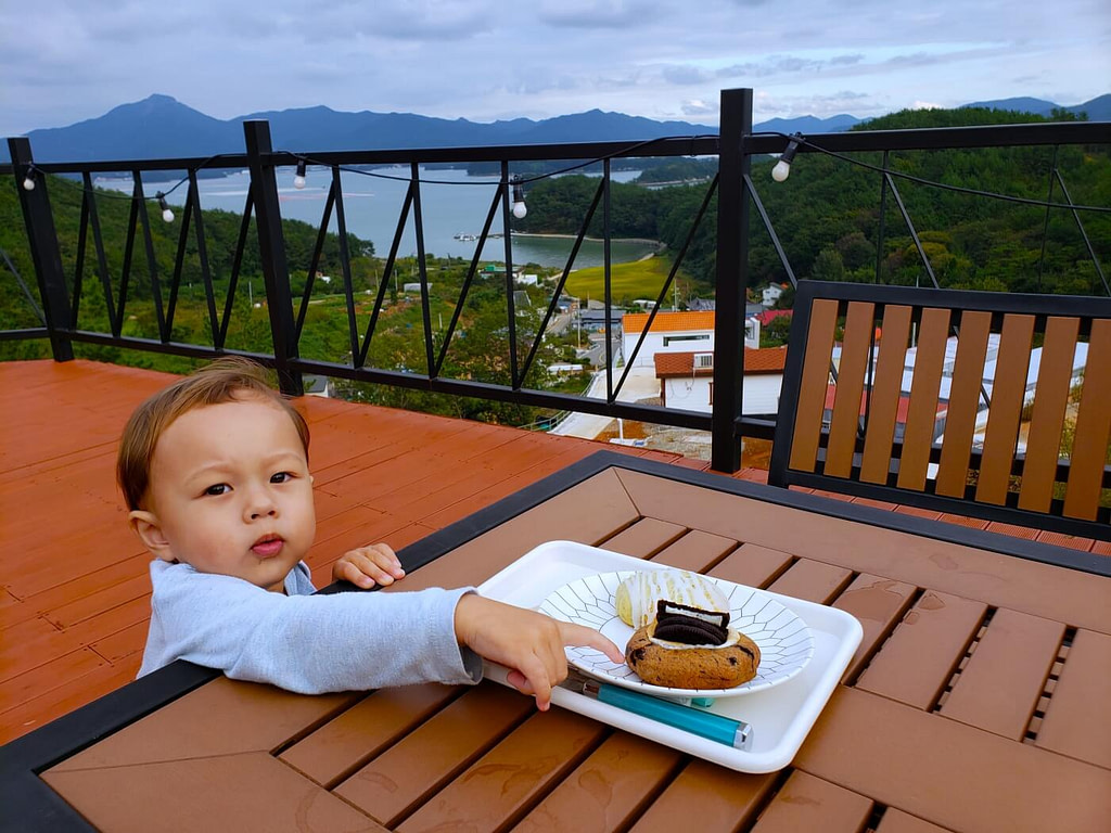 Baby Noah reaching for a cookie on a deck