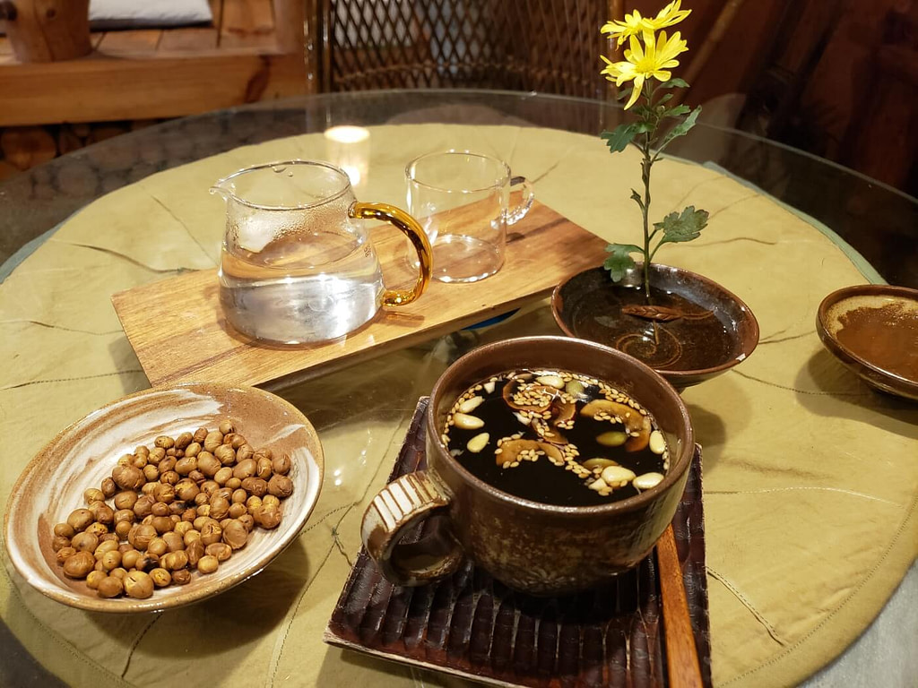 A cup of traditional healthy tea on a table with accompanying tableware