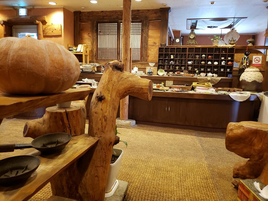 A gourd and iron cookware on a wooden shelf in a teahouse