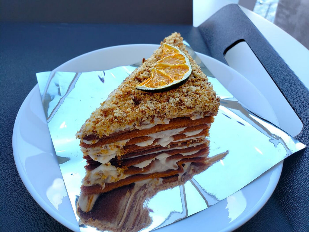 A piece of multi-layered cake with a piece of dried fruit on top