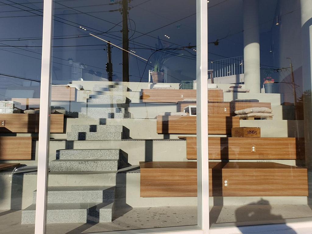 Seating on steps facing a large front window in Café Zaha