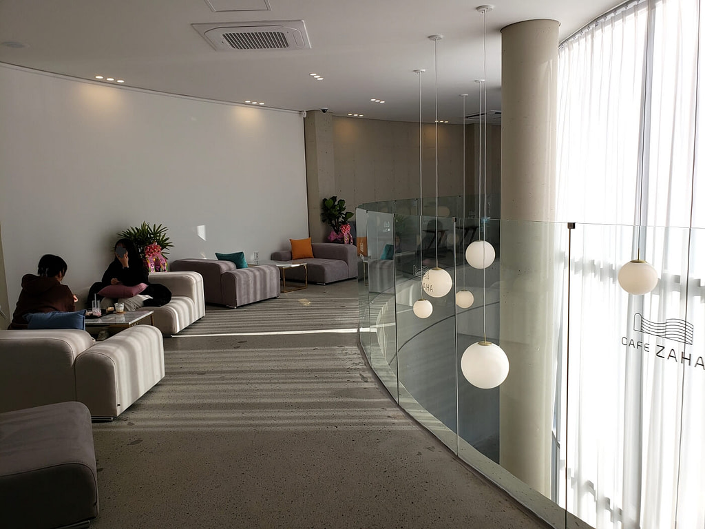 Soft sofa seating on the second floor of Café Zaha with dangling spherical lights