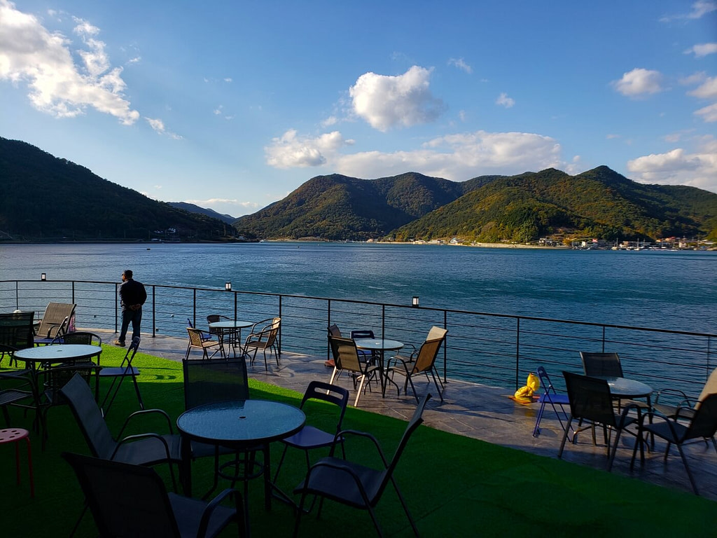 Tables and chairs outside along the water and mountains