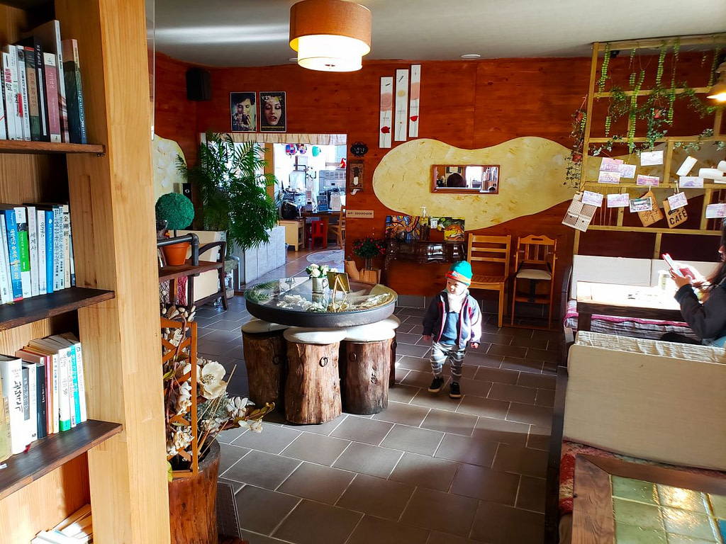 A toddler walking around a café with a table supported by stumps