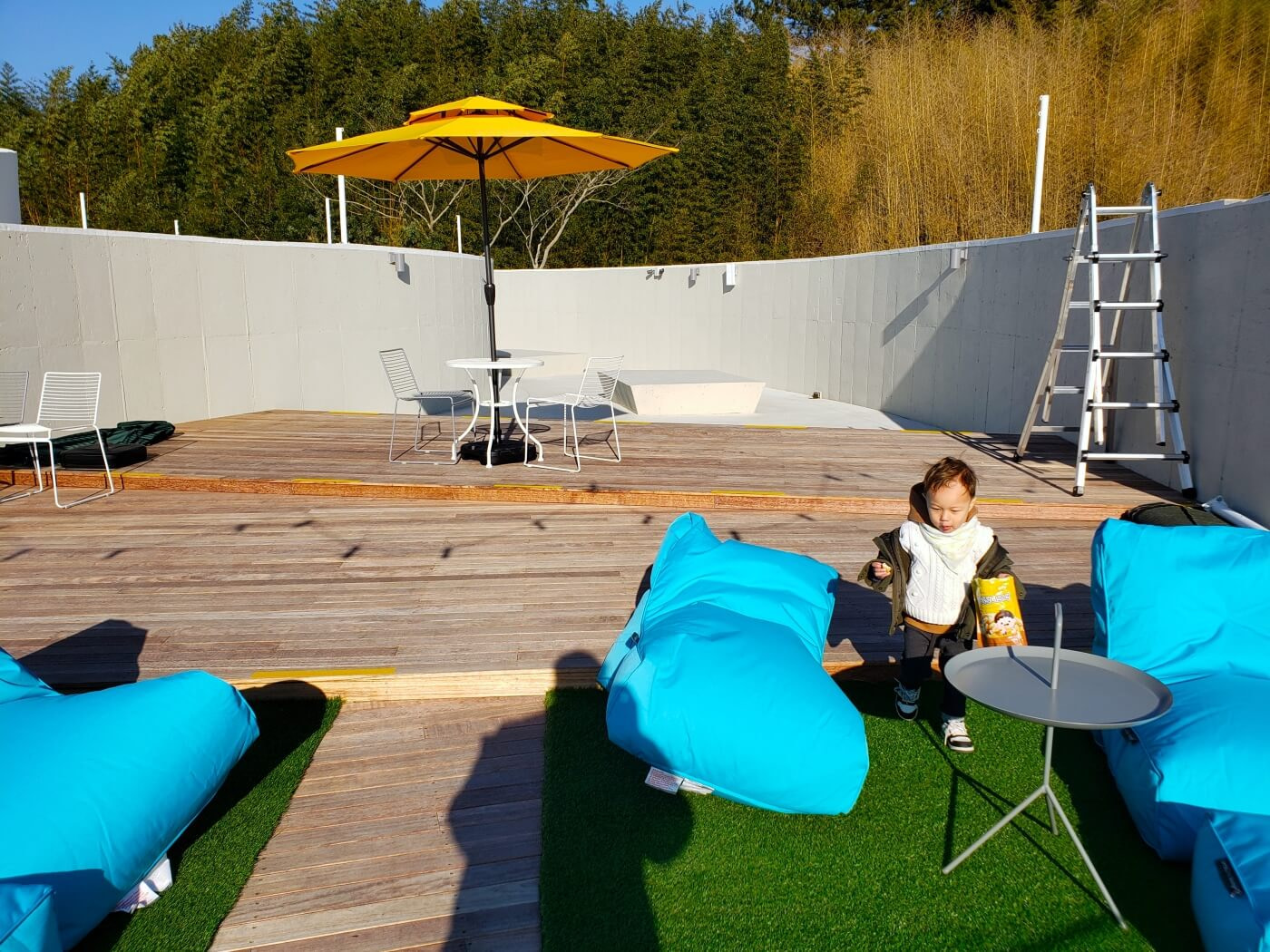 Baby Noah between blue bean bag sacks on a rooftop