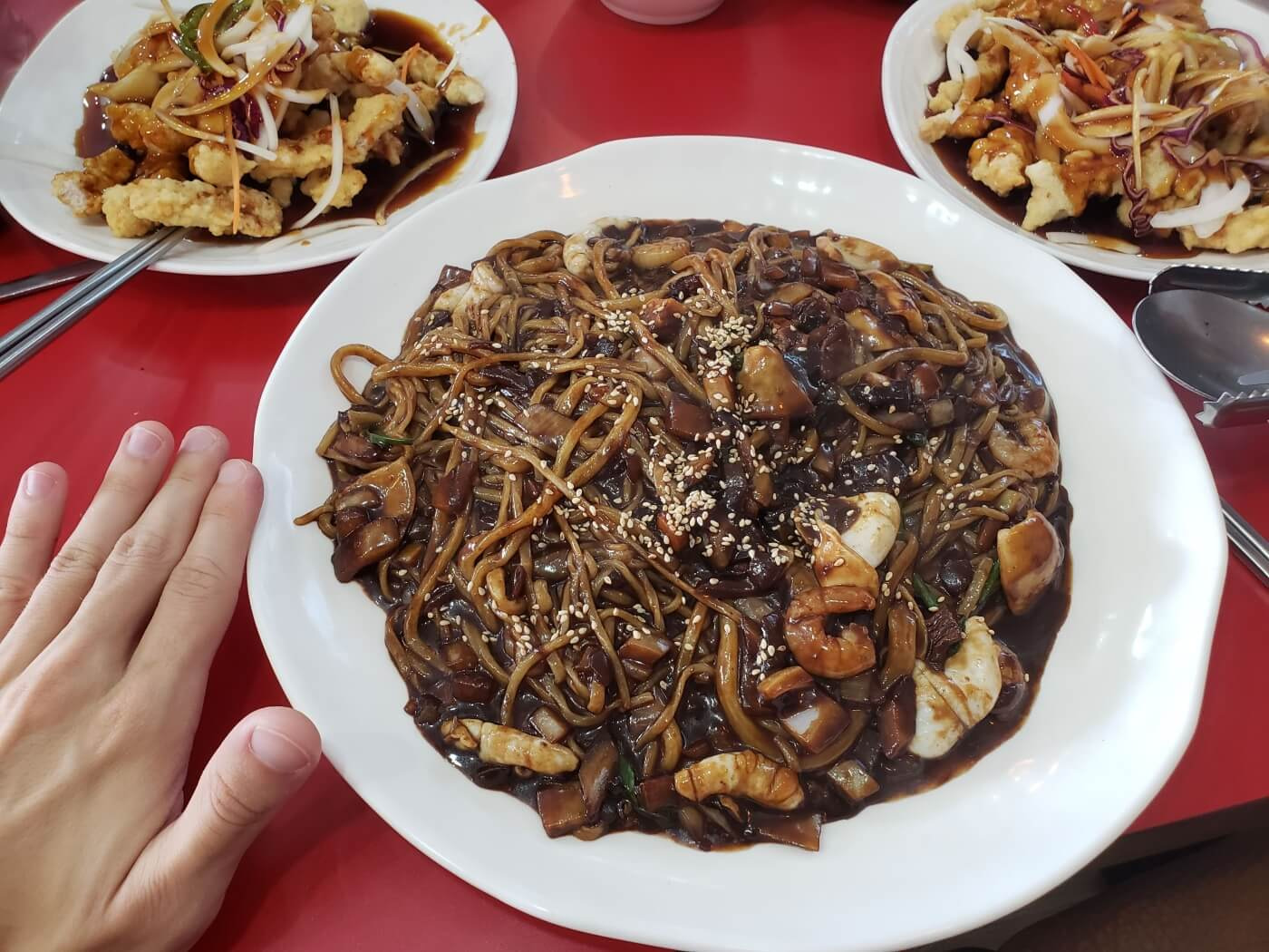 A large bowl of seafood jjajangmyeon on a table