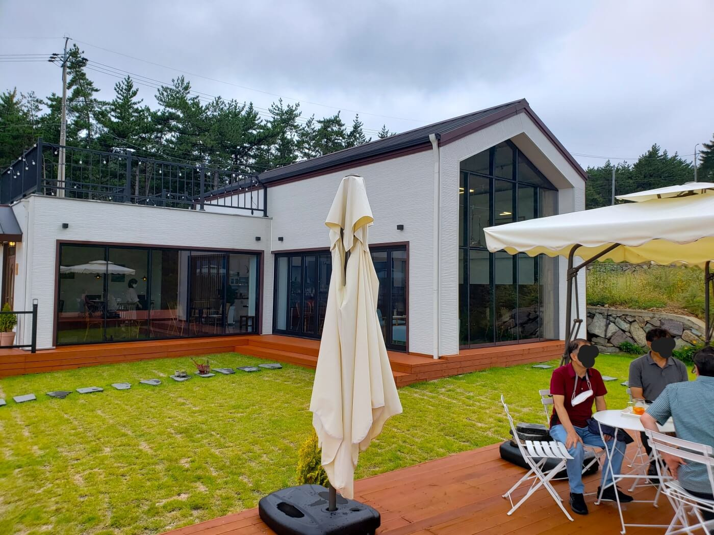 People sitting at tables under an umbrella