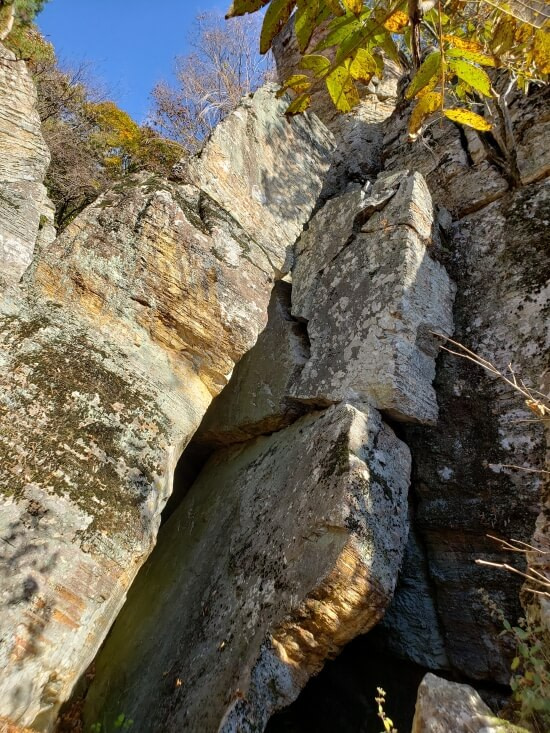 A large leaning rock and another large piece broken
