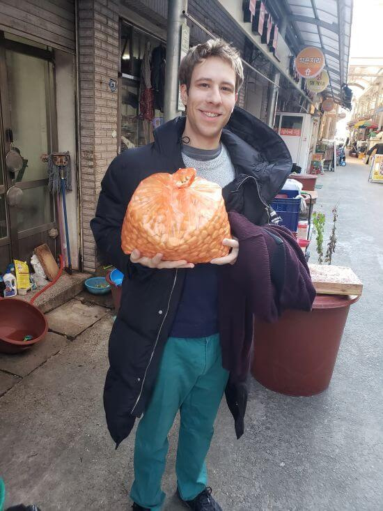 Nate standing with a large bag of garlic