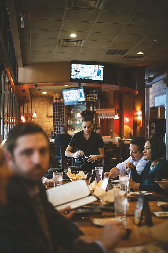 Staff taking orders at a western restaurant with mounted TVs