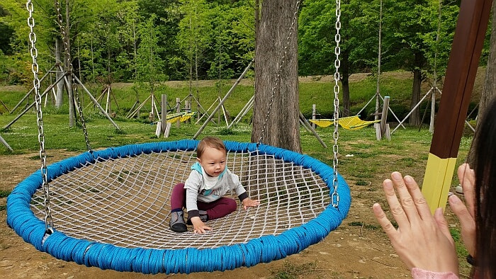 Noah sitting on the netted circular swing
