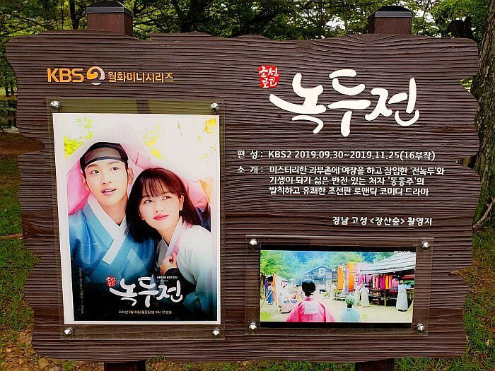 A signpost with a photos and writing about a KBS2 drama filmed at Jangsan forest