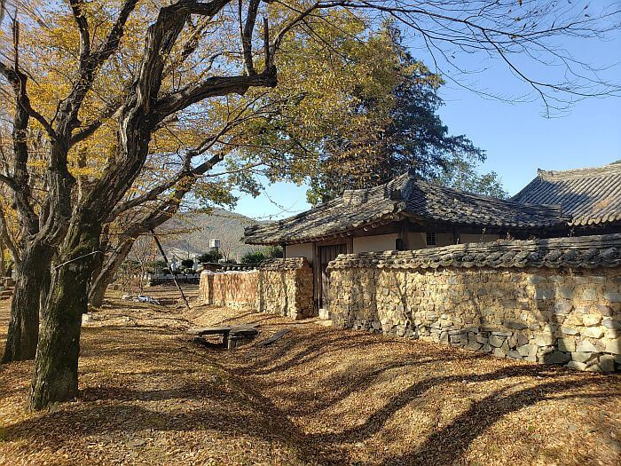 An old, mud and stone wall at Jangsan Forest in autumn