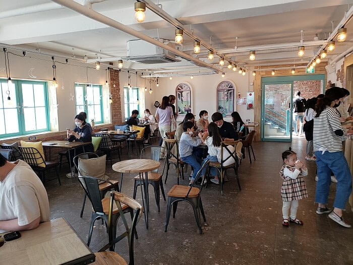 People inside café doors standing to order and sitting at various tables