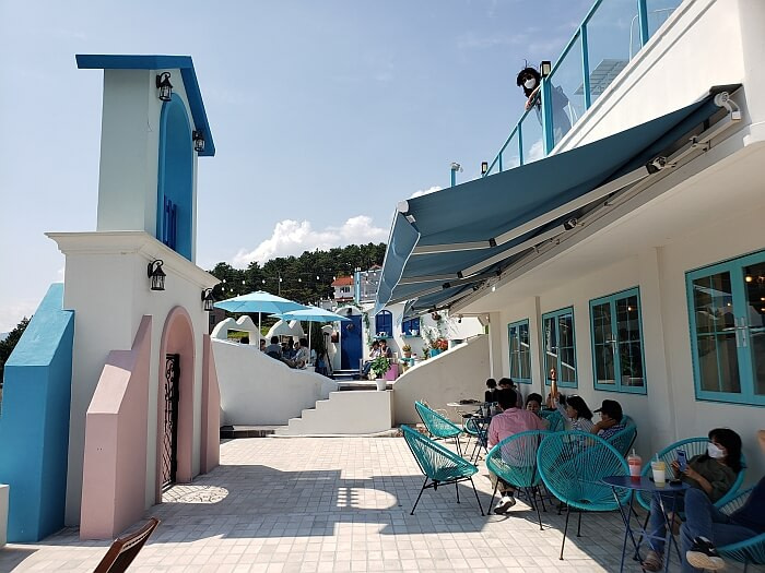 People sitting in the shade under an awning on a sunny day