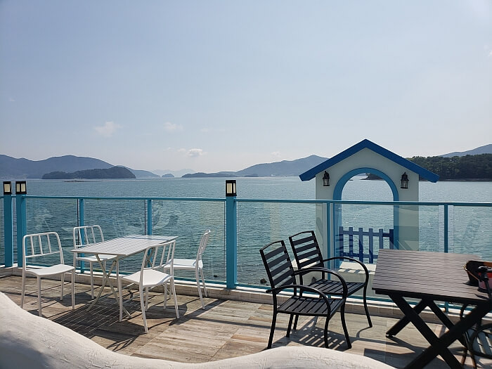 Tables on a balcony overlooking the sea at Doors Café