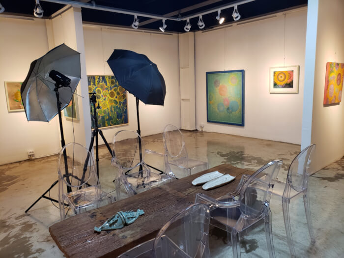 Inside the gallery with a wooden table and chairs in the middle