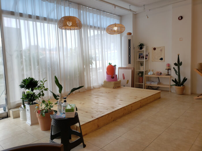 A cozy floor seating area surrounded by plants and drapes