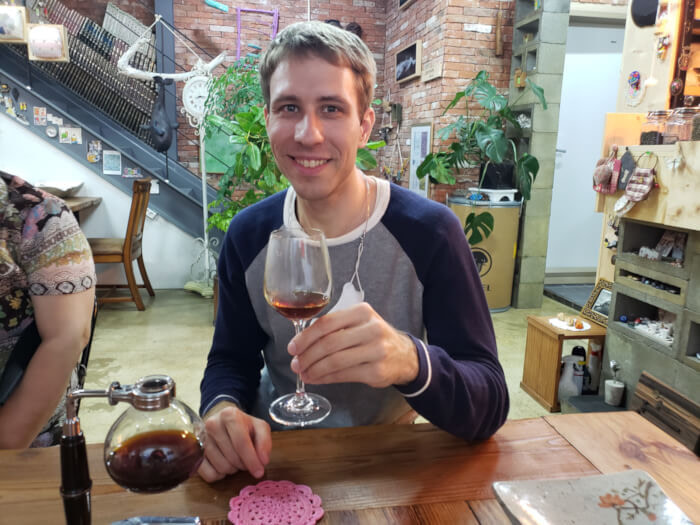 Nate drinking coffee from the siphon in a wine glass