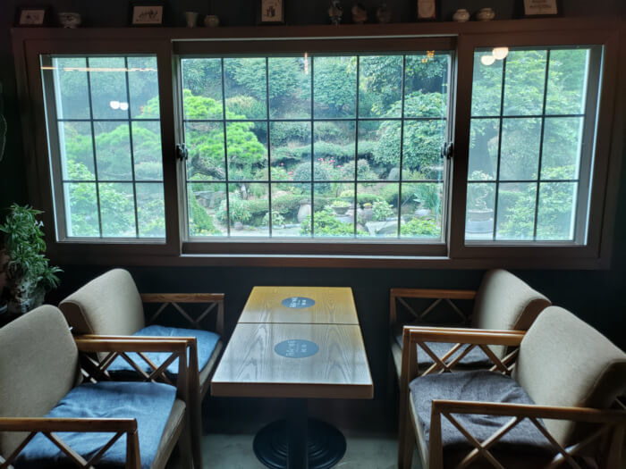Table by the window with a nice view of green plants in the garden