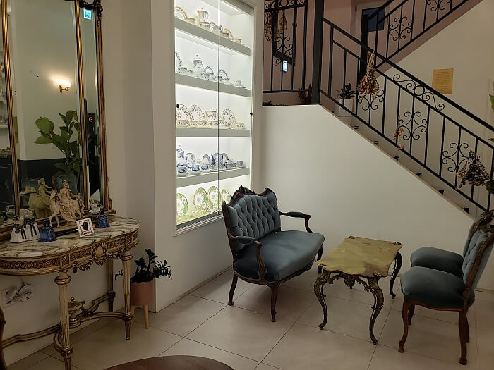 Many dishes on shelves on a wall next to stairs