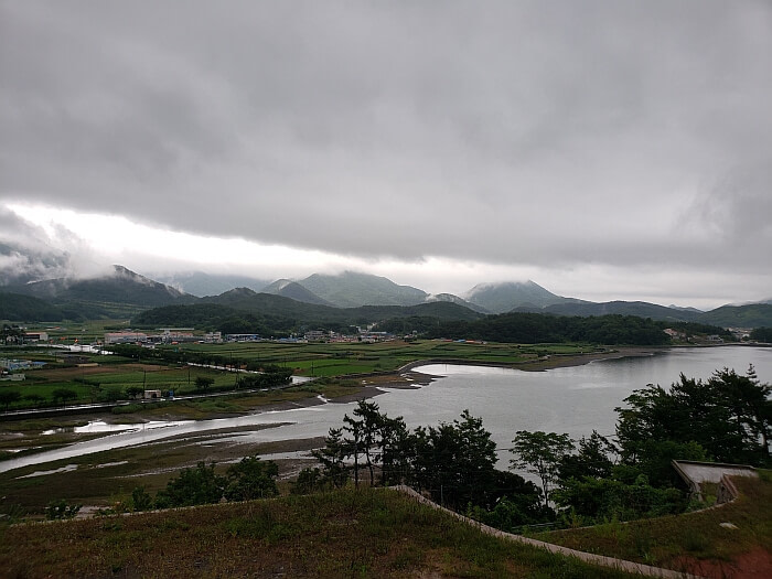 Clouds over the mountains and water after a rain with rice fields below