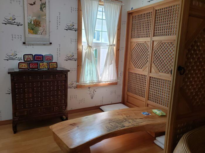 A small room for groups with a low table for sitting on the floor and sun shining through window with white curtains