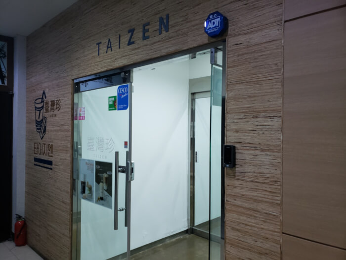 Entrance to café on second floor with sign above glass doors