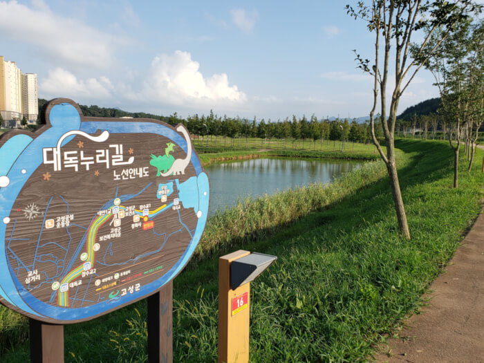 A signpost showing the Daedok Nurigil trekking trail at Baegse Park along the reservoir