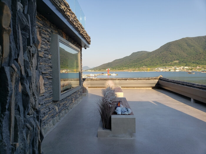 The second floor balcony has benches and overlooks the water and mountains