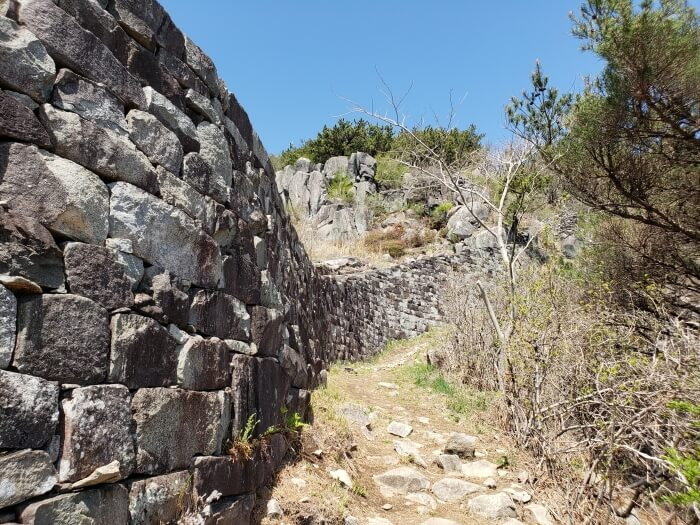 Closeup of the Goseong Fortress Wall along Georyusan against a blue sky